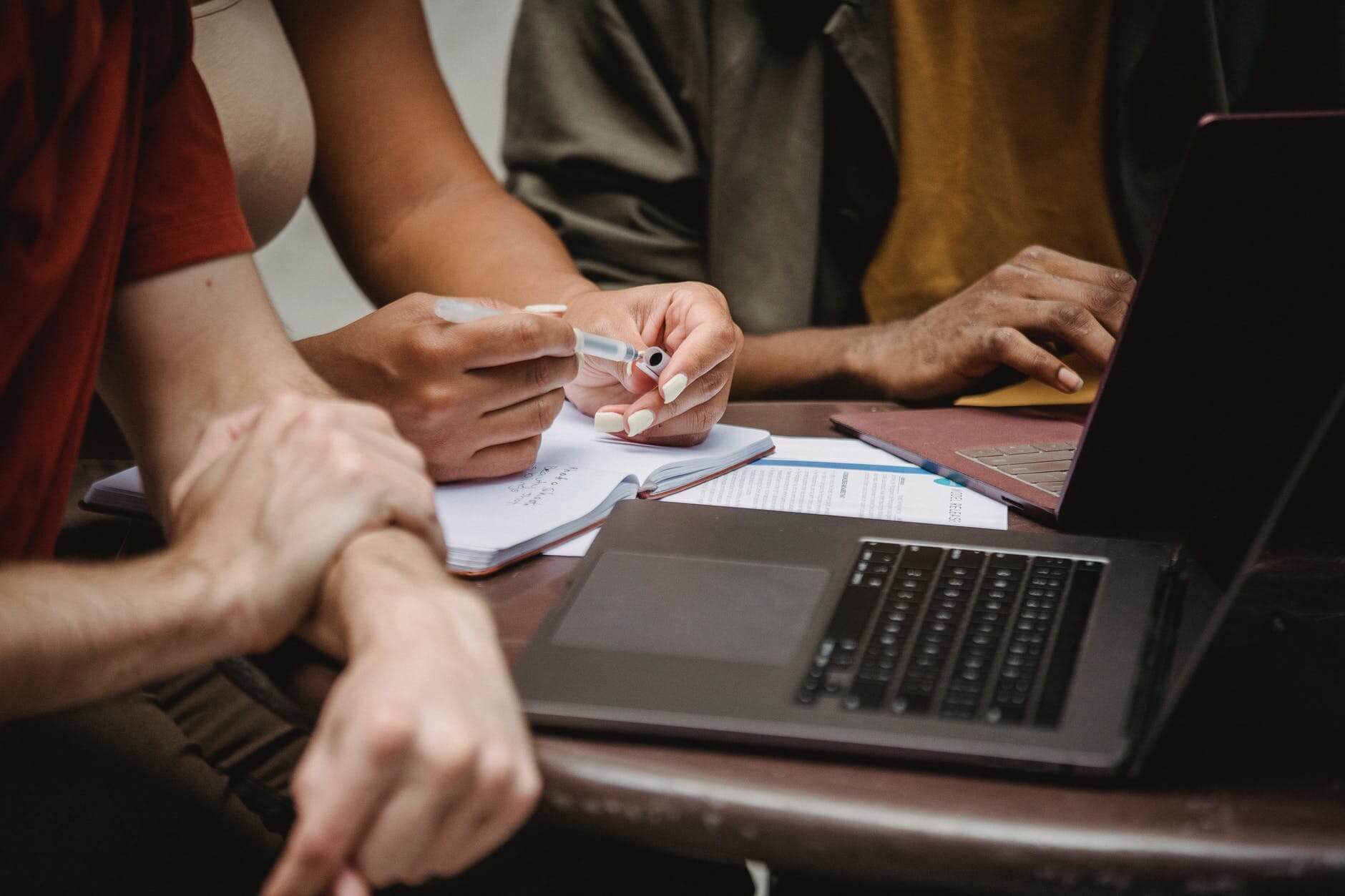 crop multiethnic friends working on startup using laptops in office